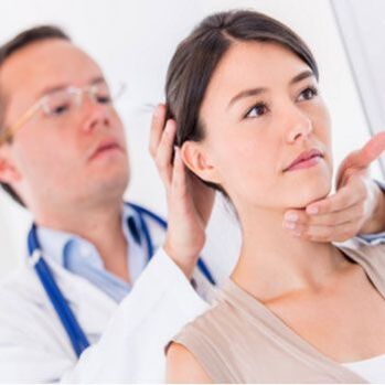 Neurolog bada pacjenta z bólem szyi